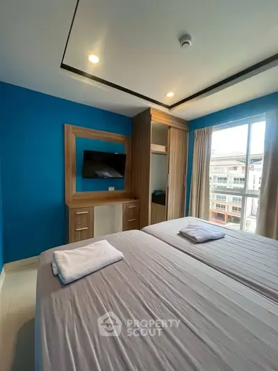 Modern bedroom with blue accent wall and large window view