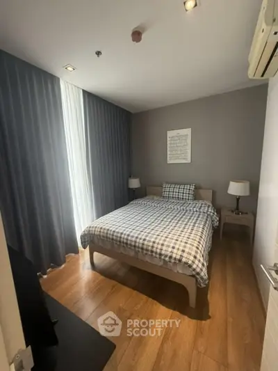Cozy bedroom with wooden flooring and modern decor in a stylish apartment