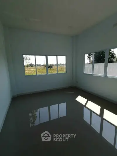 Spacious empty room with large windows offering natural light and scenic views, perfect for customization.