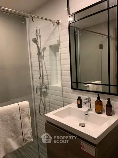 Modern bathroom with sleek shower and stylish vanity in contemporary apartment.