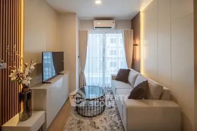 Modern living room with cozy sofa, stylish decor, and natural light through large window.