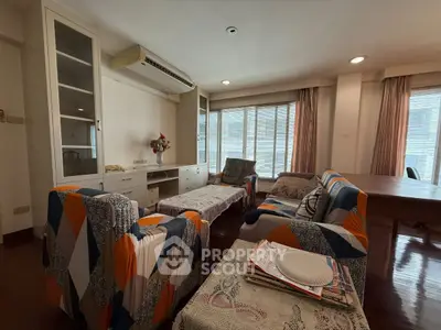Spacious living room with colorful furniture and large windows in a modern apartment.