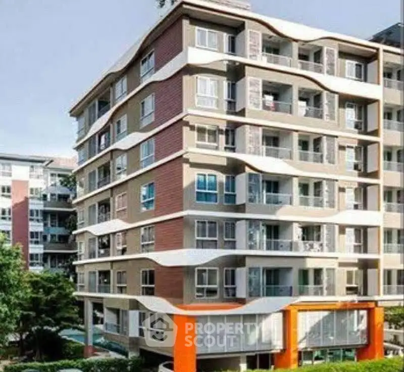 Modern multi-story apartment building with unique architectural design and large windows.