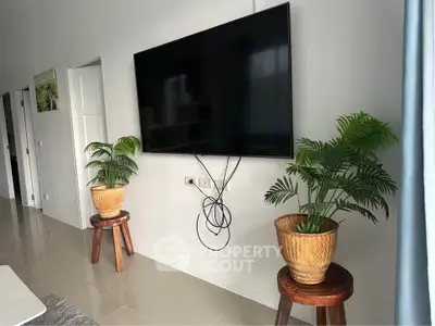 Modern living room with wall-mounted TV and stylish plant decor