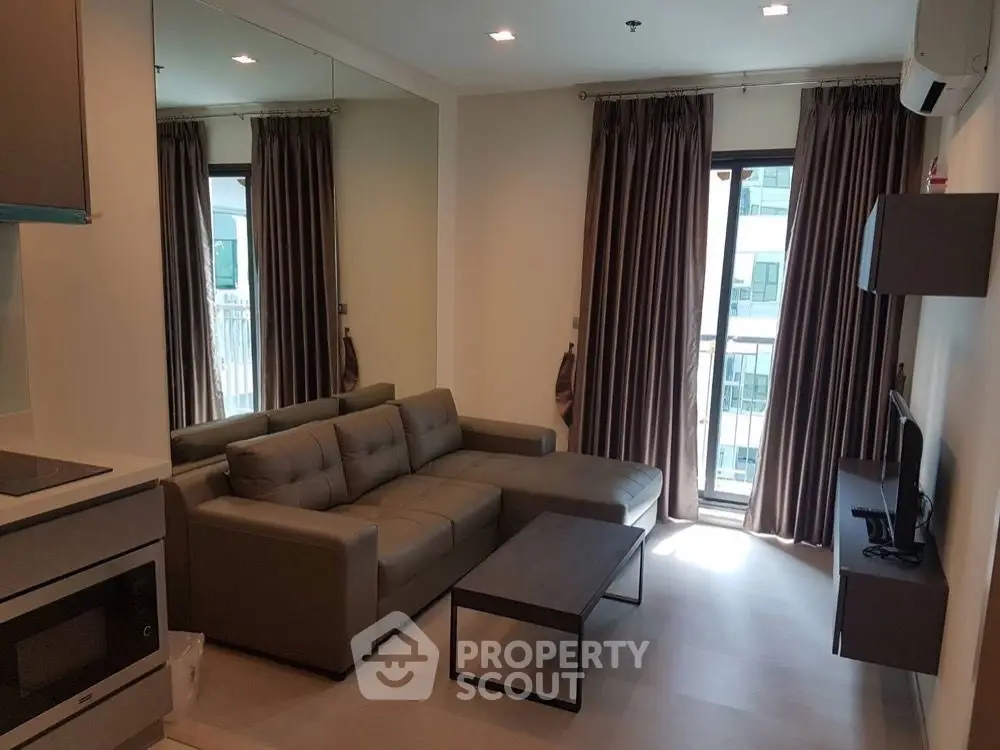 Modern living room with sleek furniture and large window in a stylish apartment.