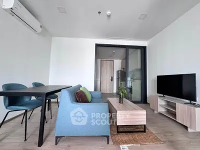 Modern living room with sleek furniture and open kitchen layout in a stylish apartment.