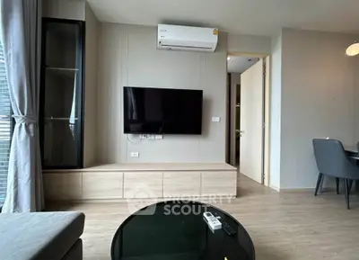 Modern living room with wall-mounted TV and air conditioning in a stylish apartment.