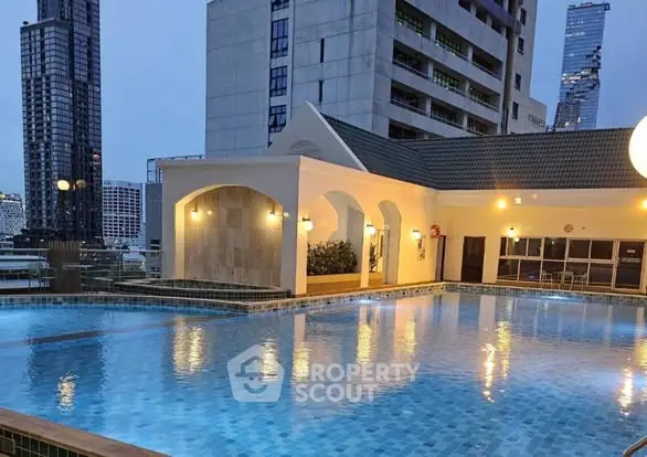 Luxurious rooftop pool with stunning cityscape views at dusk, perfect for relaxation and leisure.