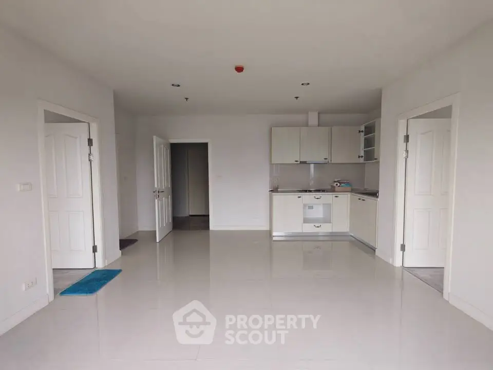 Spacious open-plan living area with modern kitchen in a bright apartment.