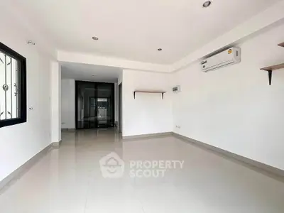 Spacious unfurnished living room with air conditioning and modern tile flooring