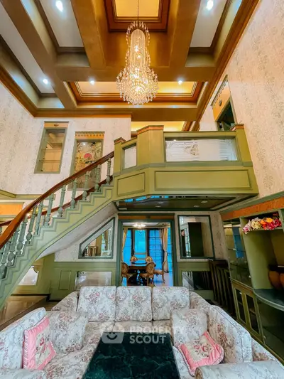 Luxurious living room with elegant chandelier and grand staircase