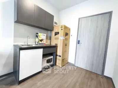 Modern compact kitchen with new appliances and sleek cabinetry in a stylish apartment.