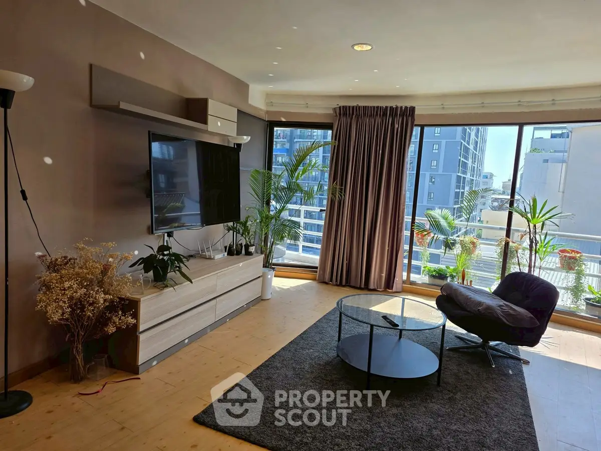 Spacious living room with large windows and modern decor in urban apartment