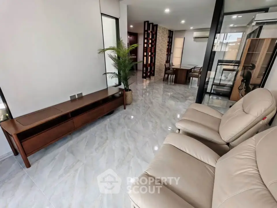 Spacious modern living room with sleek flooring and elegant furniture, perfect for relaxation and entertainment.