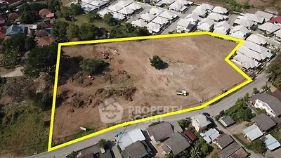 Aerial view of a large plot of land outlined in yellow, ideal for development in a residential area.