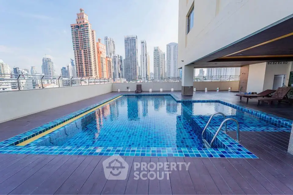 Stunning rooftop pool with city skyline views in a modern high-rise building.