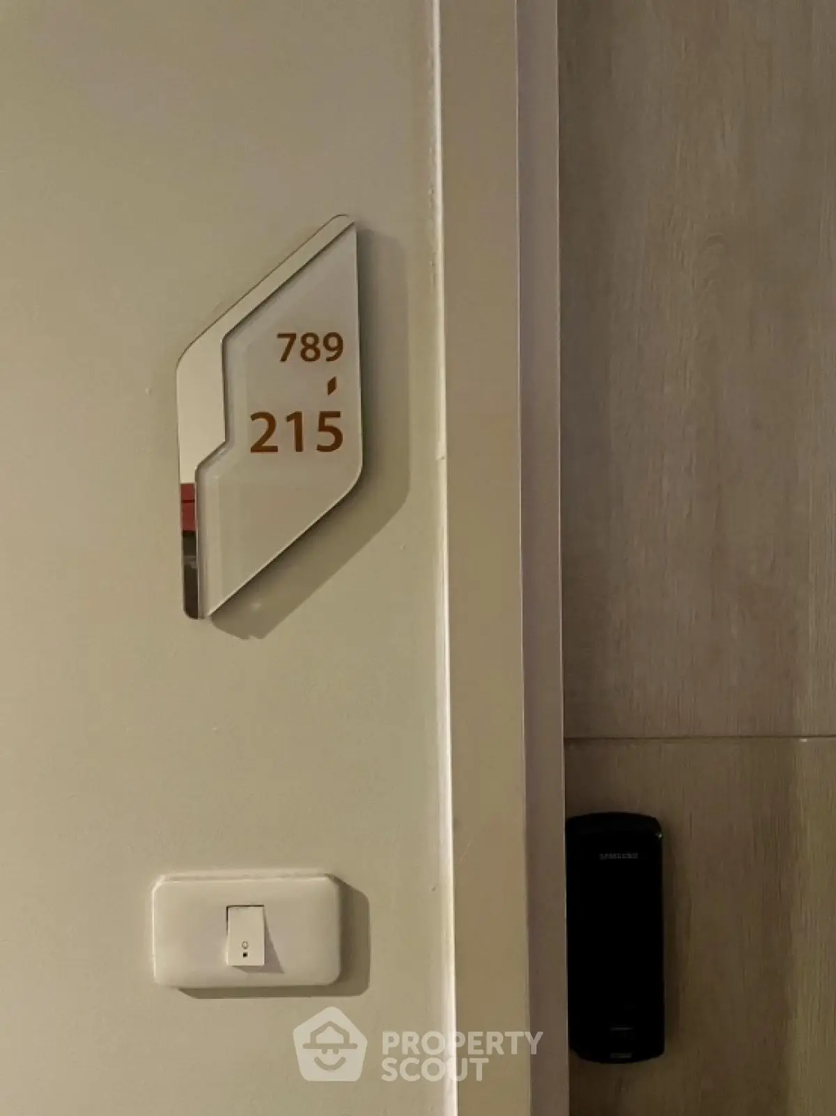 Modern apartment entrance with electronic lock and room number signage