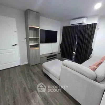 Modern living room with sleek design, featuring a cozy sofa, wall-mounted TV, and elegant flooring.