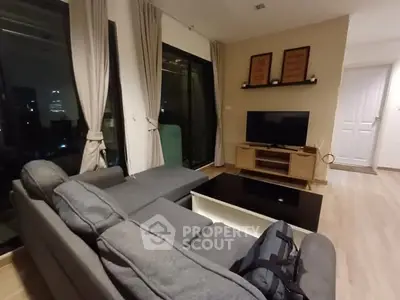 Modern living room with cozy gray sofa and large TV, perfect for relaxation.