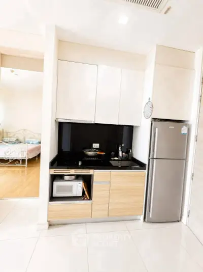 Modern kitchen with sleek cabinetry and stainless steel appliances in a stylish apartment.