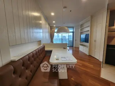 Modern living room with built-in seating and city view, featuring sleek wooden flooring and stylish lighting.