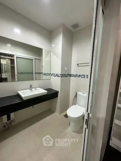 Modern bathroom with sleek design, featuring a stylish sink and toilet, ideal for contemporary living.