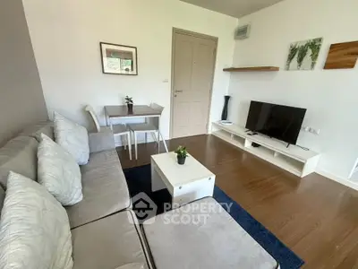 Modern living room with cozy sofa, TV, and dining area in stylish apartment.