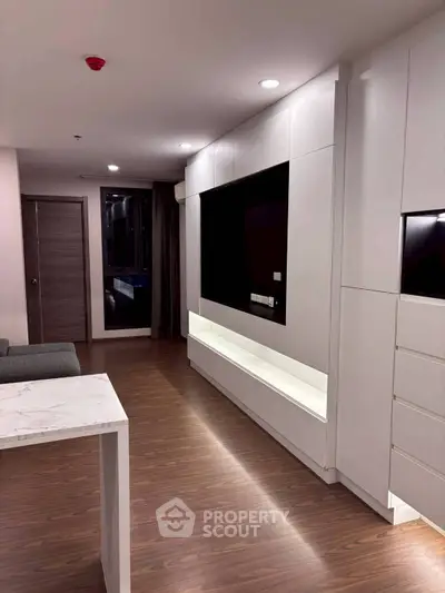 Modern living room with sleek white cabinetry and wood flooring