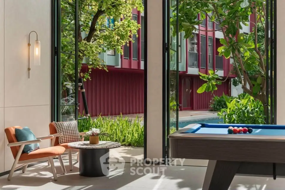 Luxurious living room with pool table and garden view, perfect for entertainment and relaxation.