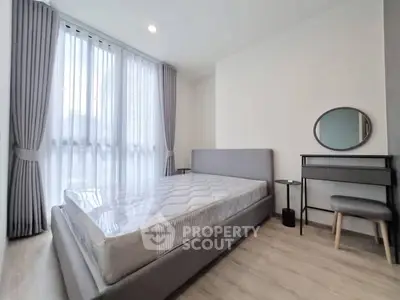 Modern bedroom with large window, stylish bed, and elegant decor in a bright apartment.