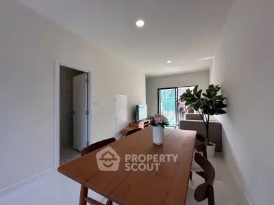 Modern living room with wooden dining table and balcony view