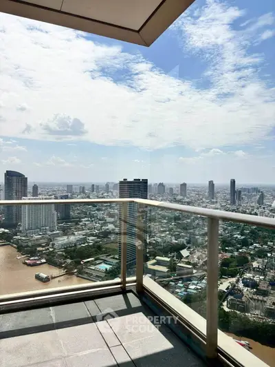 Stunning high-rise balcony with panoramic city view and clear blue sky.