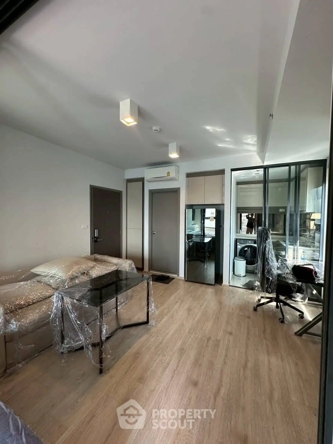 Modern living room with sleek furniture and wooden flooring in a stylish apartment.