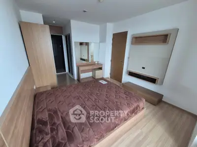 Modern bedroom with wooden furniture and cozy brown bedding in a stylish apartment.