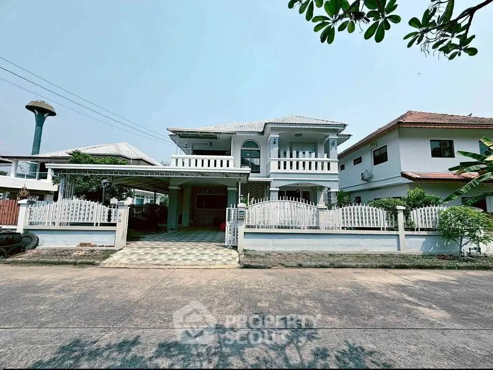 Charming two-story house with white picket fence and spacious driveway