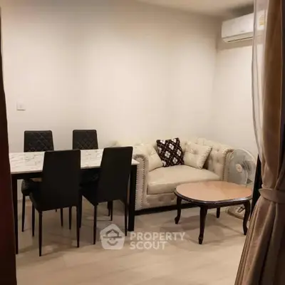 Cozy living room with elegant dining set and plush sofa, perfect for intimate gatherings.
