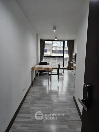 Modern apartment interior with open layout dining and living area, featuring large windows and stylish flooring.