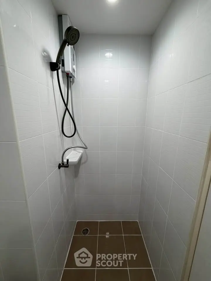 Compact modern bathroom with sleek shower and white tiled walls