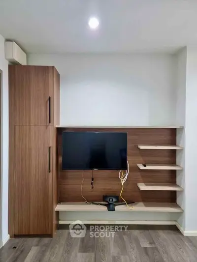 Modern living room with sleek wooden TV unit and shelves