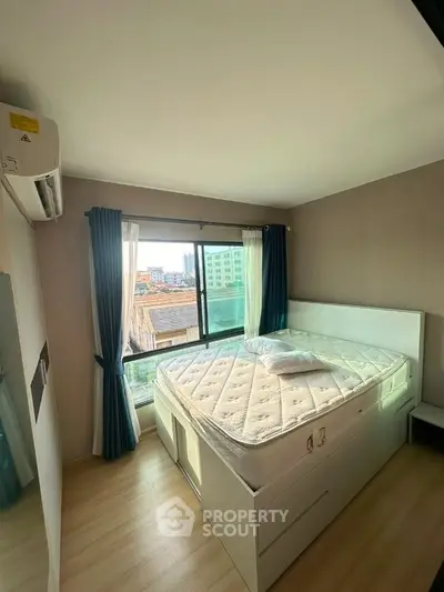 Cozy bedroom with large window and city view, featuring a comfortable bed and modern decor.