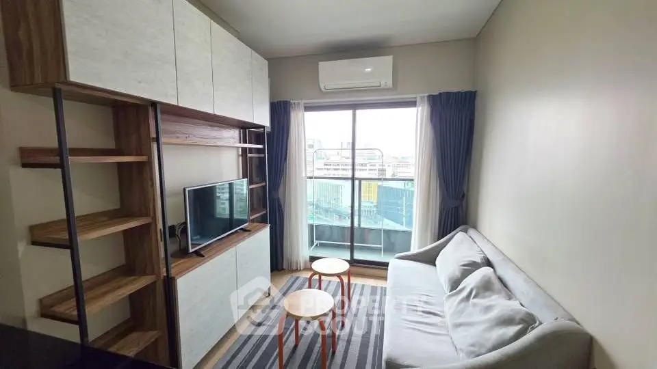Modern living room with stylish furniture and balcony view in urban apartment.