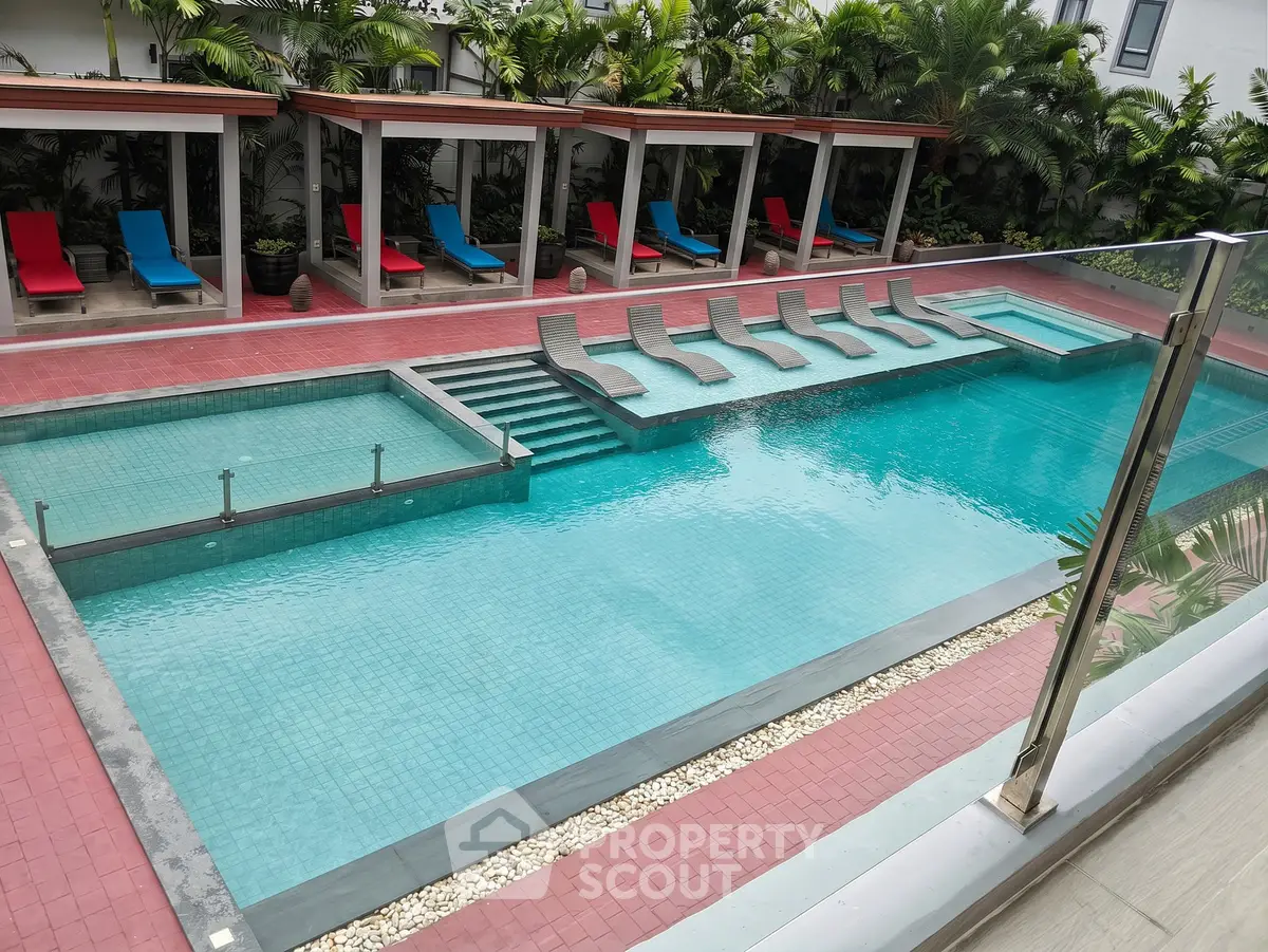 Luxurious swimming pool area with sun loungers and cabanas, perfect for relaxation and leisure.