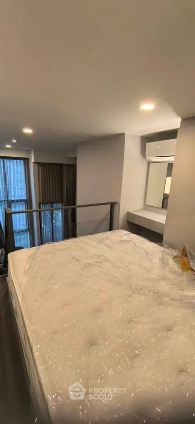 Modern bedroom with large window and air conditioning in a stylish apartment.