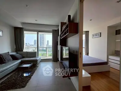 Modern apartment with spacious living room and bedroom, featuring large windows and city views.