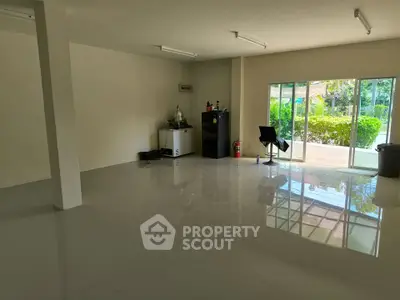 Spacious room with large windows and garden view, ideal for versatile use.