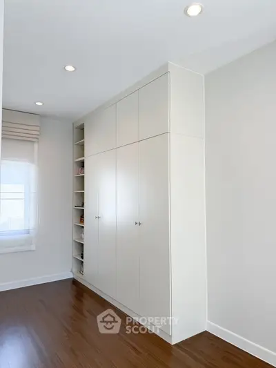 Modern bedroom with sleek built-in wardrobe and hardwood floors