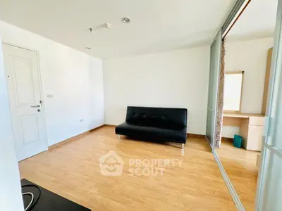 Modern minimalist living room with sleek black sofa and wooden flooring