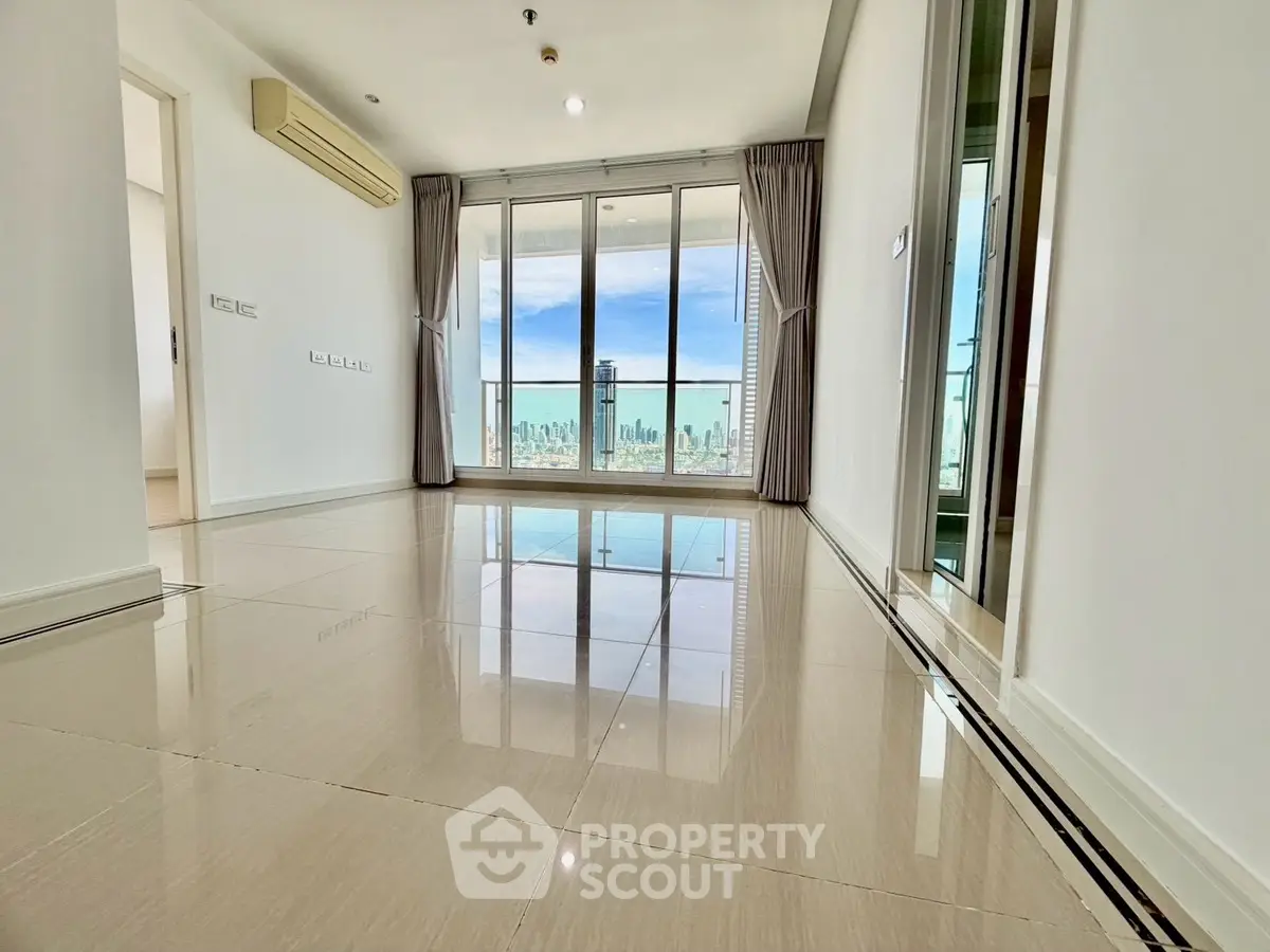 Spacious modern living room with city view and large windows in high-rise apartment.