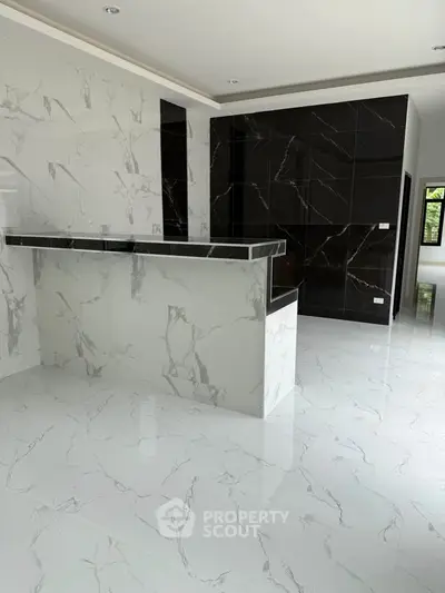 Luxurious modern kitchen with sleek marble finishes and open layout design.