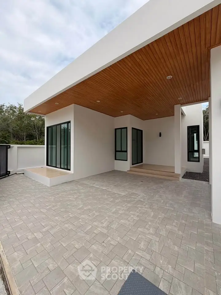 Modern minimalist home exterior with sleek design and spacious patio area.